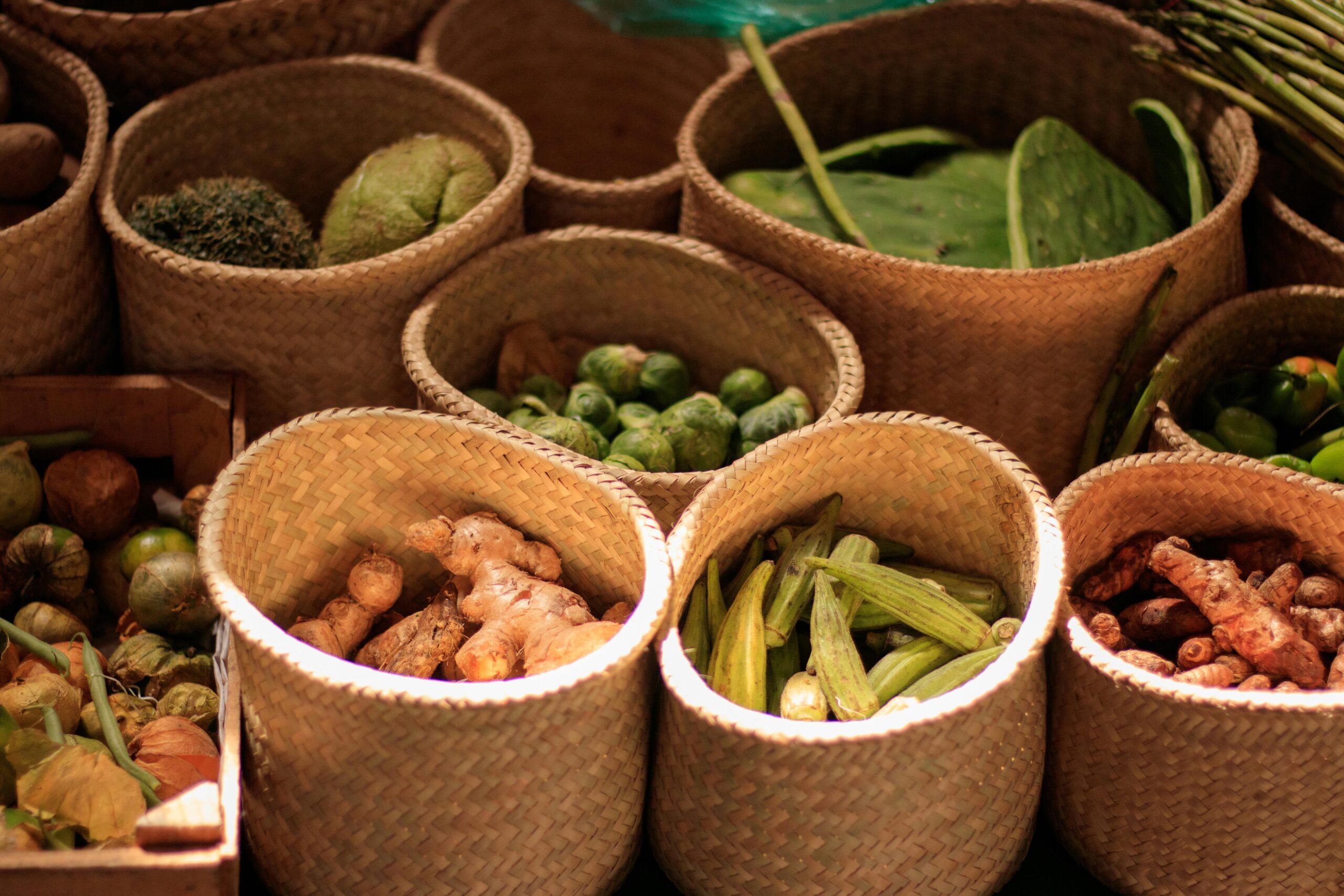 Colorful baskets of fresh vegetables at a Mexican market showcasing a variety of produce.